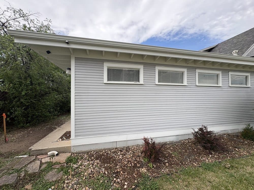 Long side elevation in gray siding with a row of clerestory windows and white trim